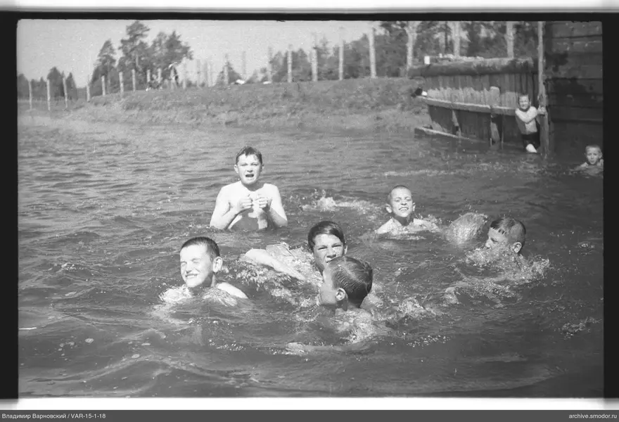 Jungen schwimmen bei einem Holzsteg