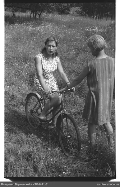 Woman with bicycle and child in a field