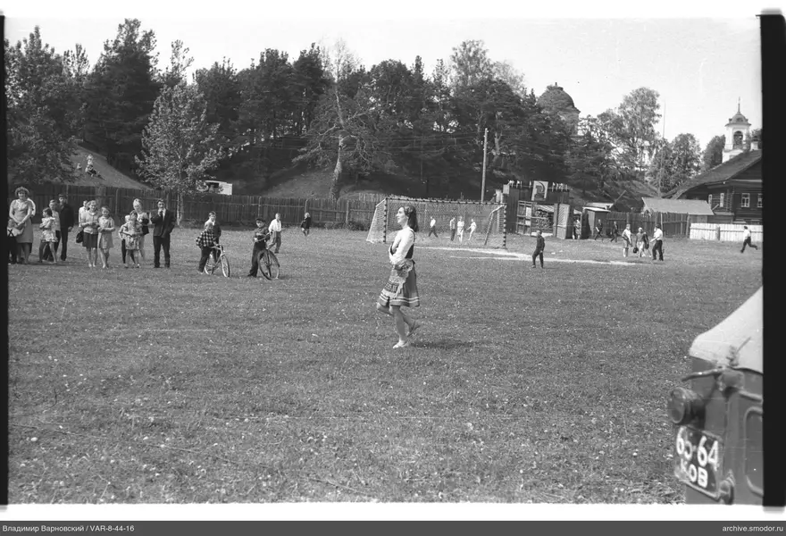 Girl on grassy field with group of people