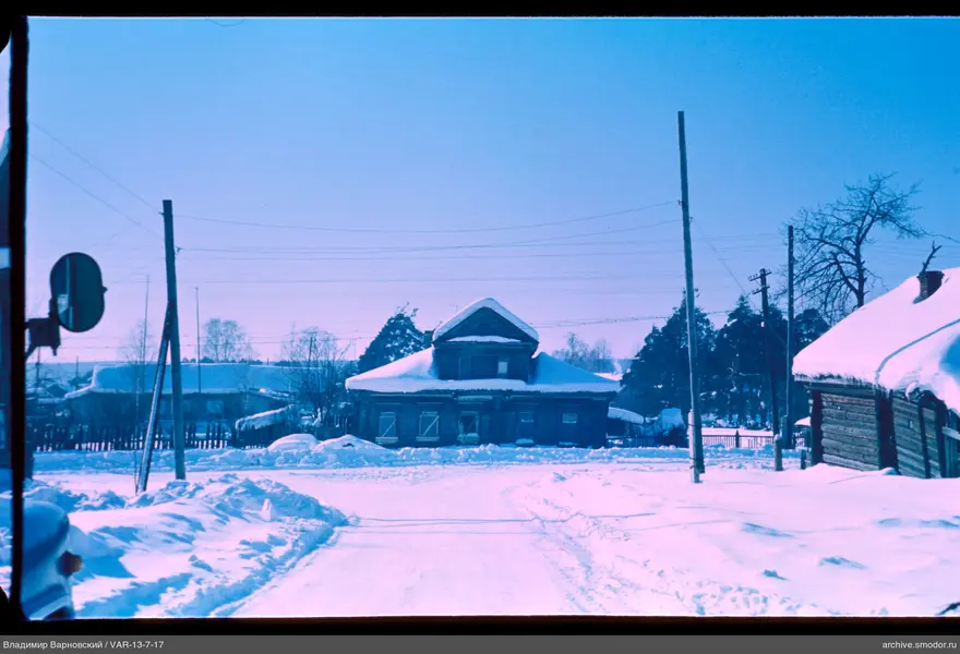 Snow-covered street with wooden houses