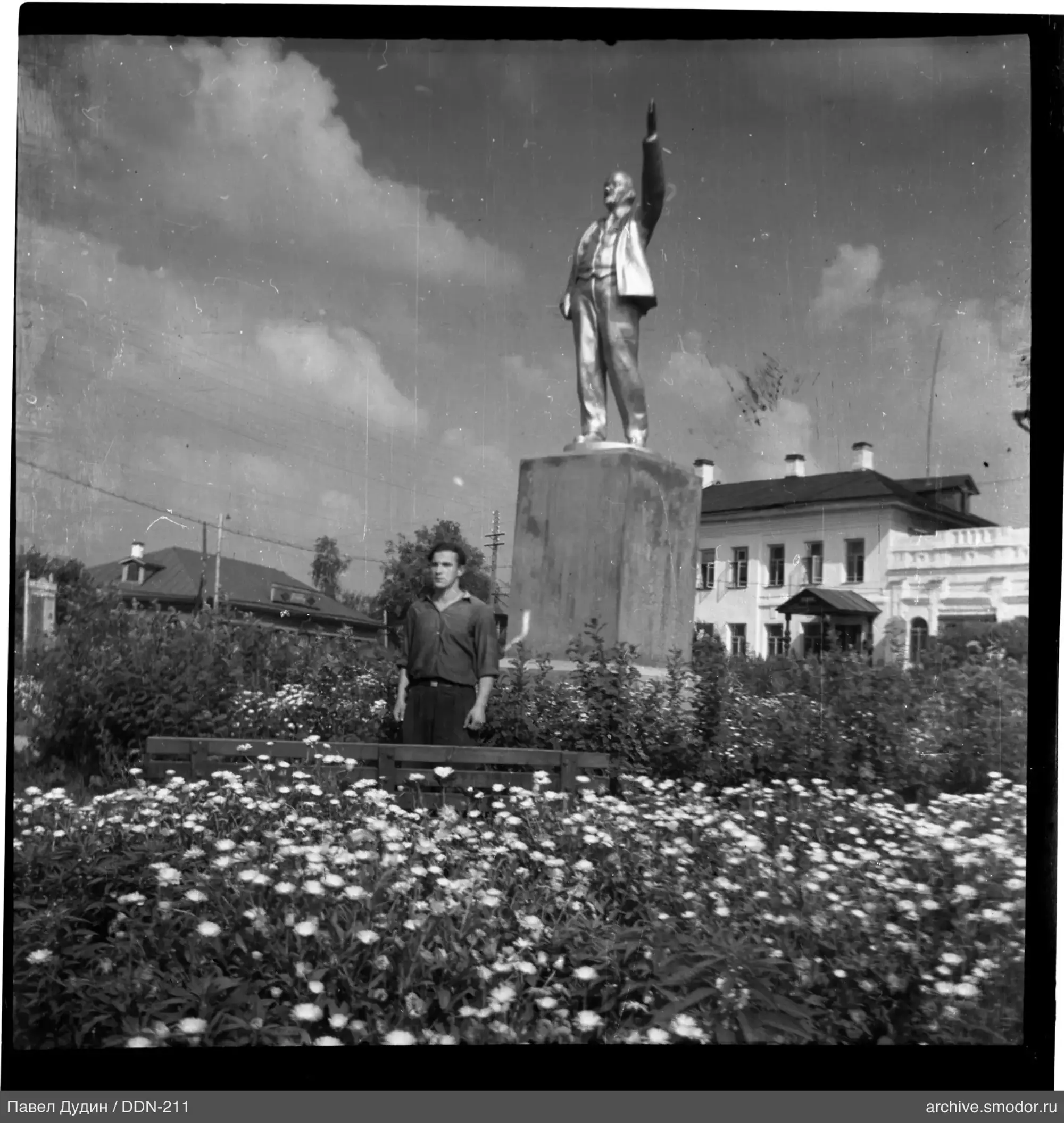 Мужчина у цветника и статуи
