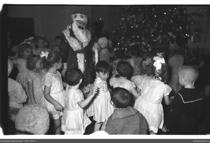 Kinder und Ded Moroz vor geschmücktem Weihnachtsbaum
