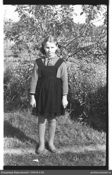 Mädchen in Kleid mit Schürze in der Natur