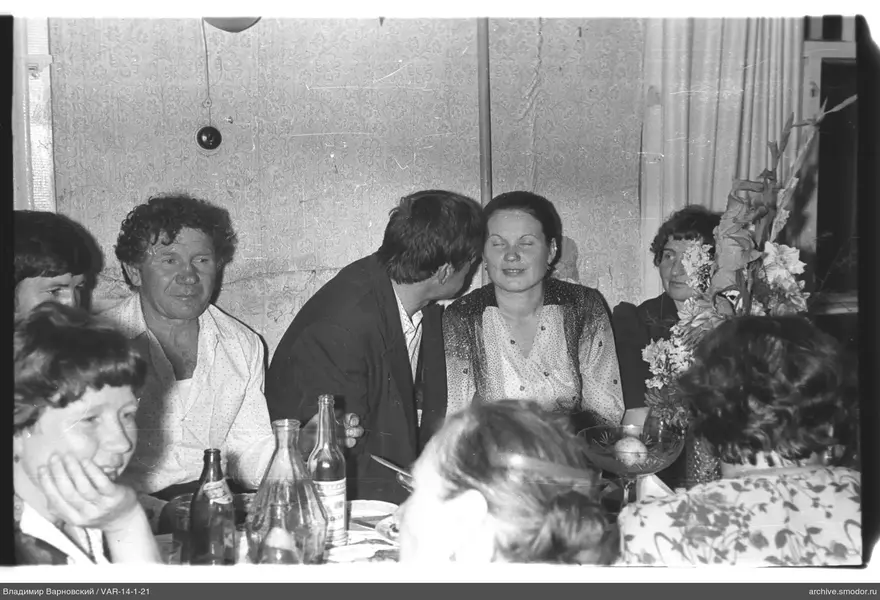 Gruppe am Tisch mit Flaschen und Blumen