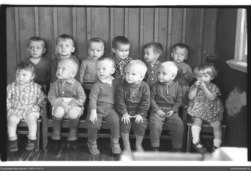 Gruppenporträt von Kindern an einer Holzwand