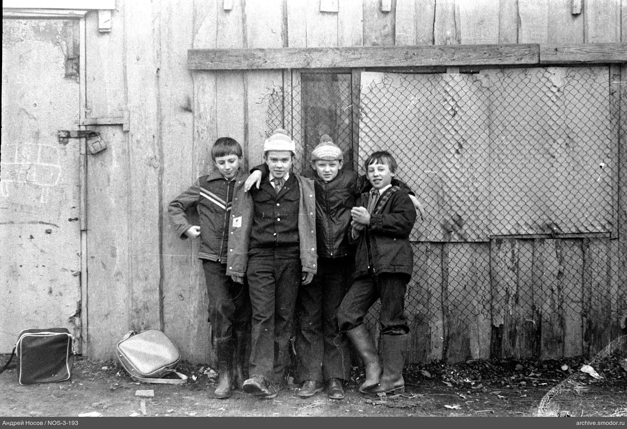 Gruppe von Jungen an einer Holzwand