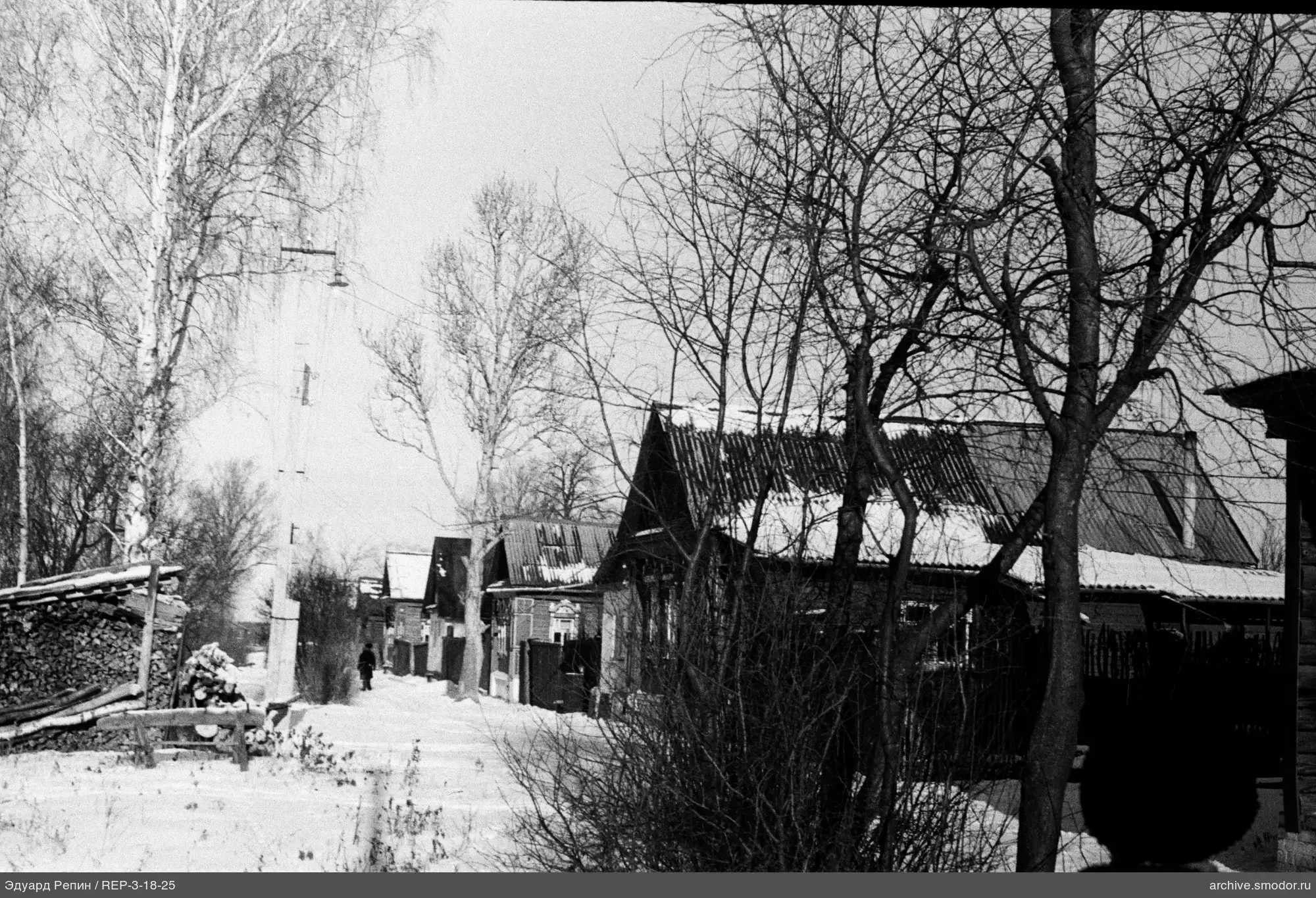 Snow-covered street with wooden houses