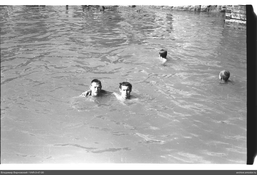 Jungen im Wasser vor Steinmauer