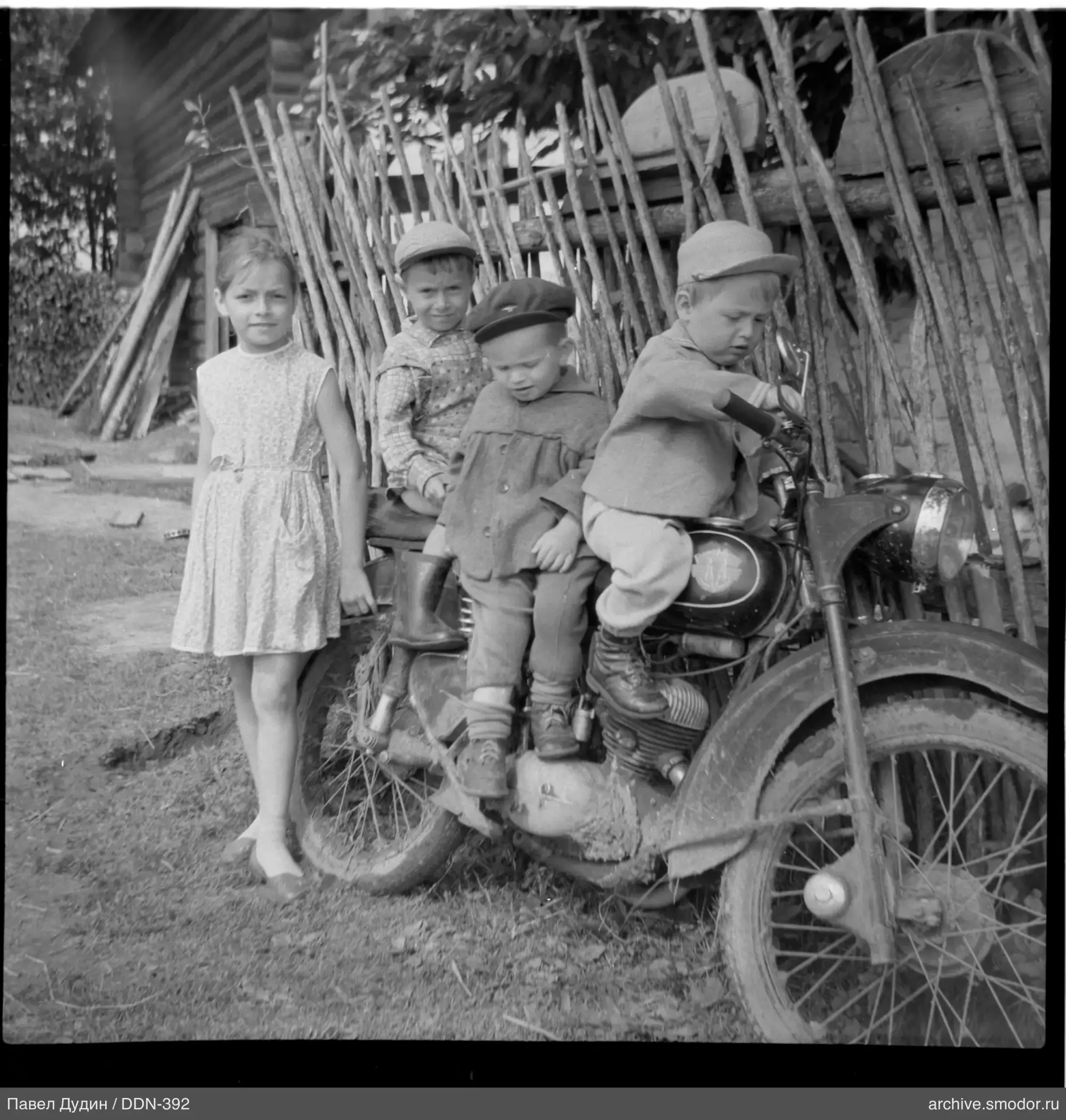 Дети у деревянного забора и дома