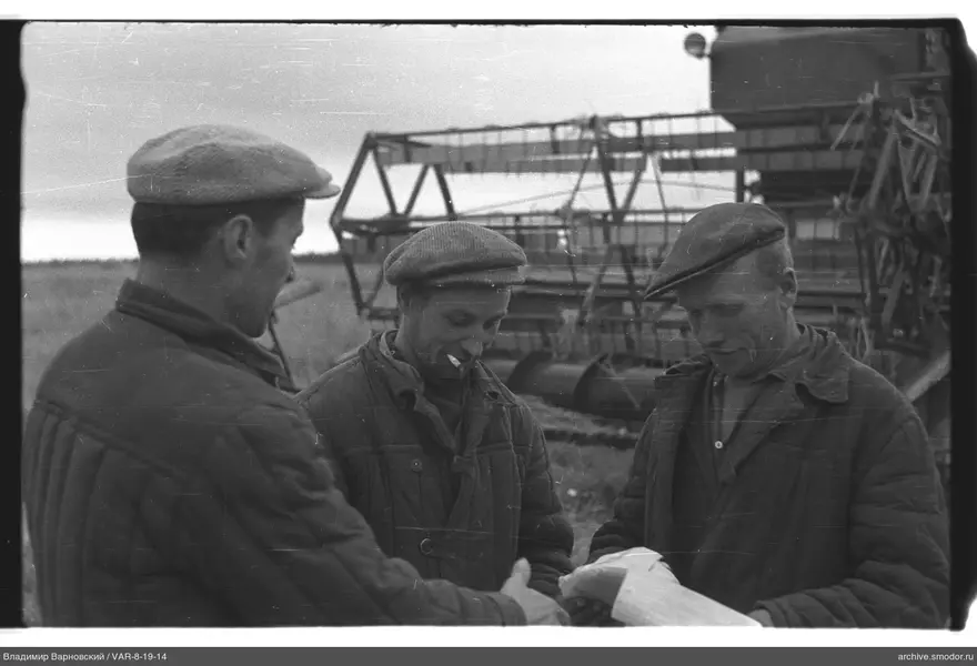 Drei Männer vor landwirtschaftlicher Maschine