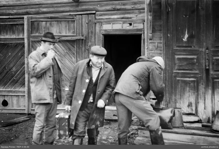 Gruppe von Männern vor einem Holzgebäude