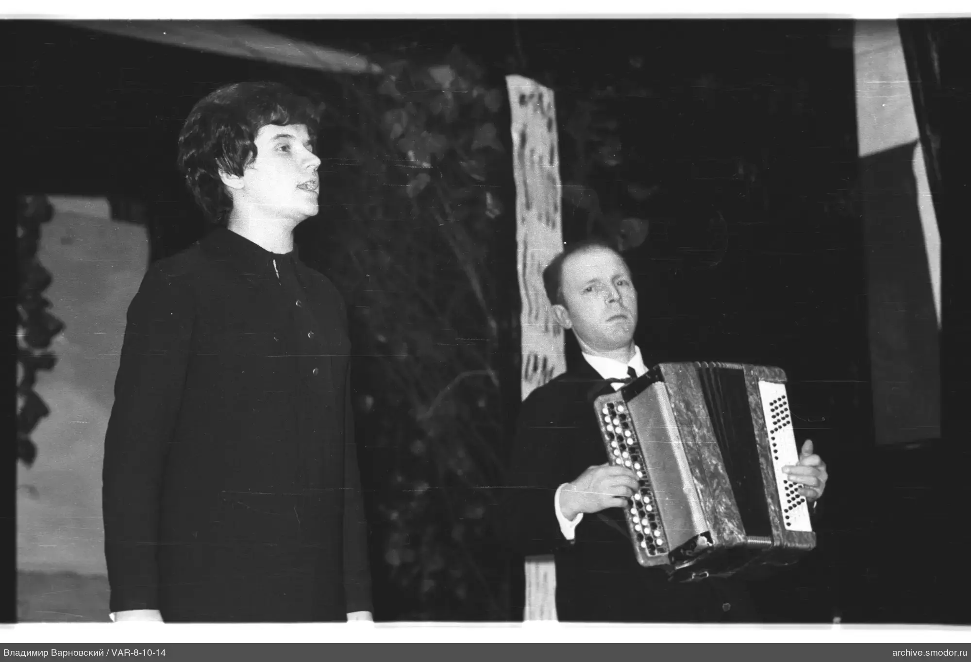 Frau singt und Mann spielt Bayan
