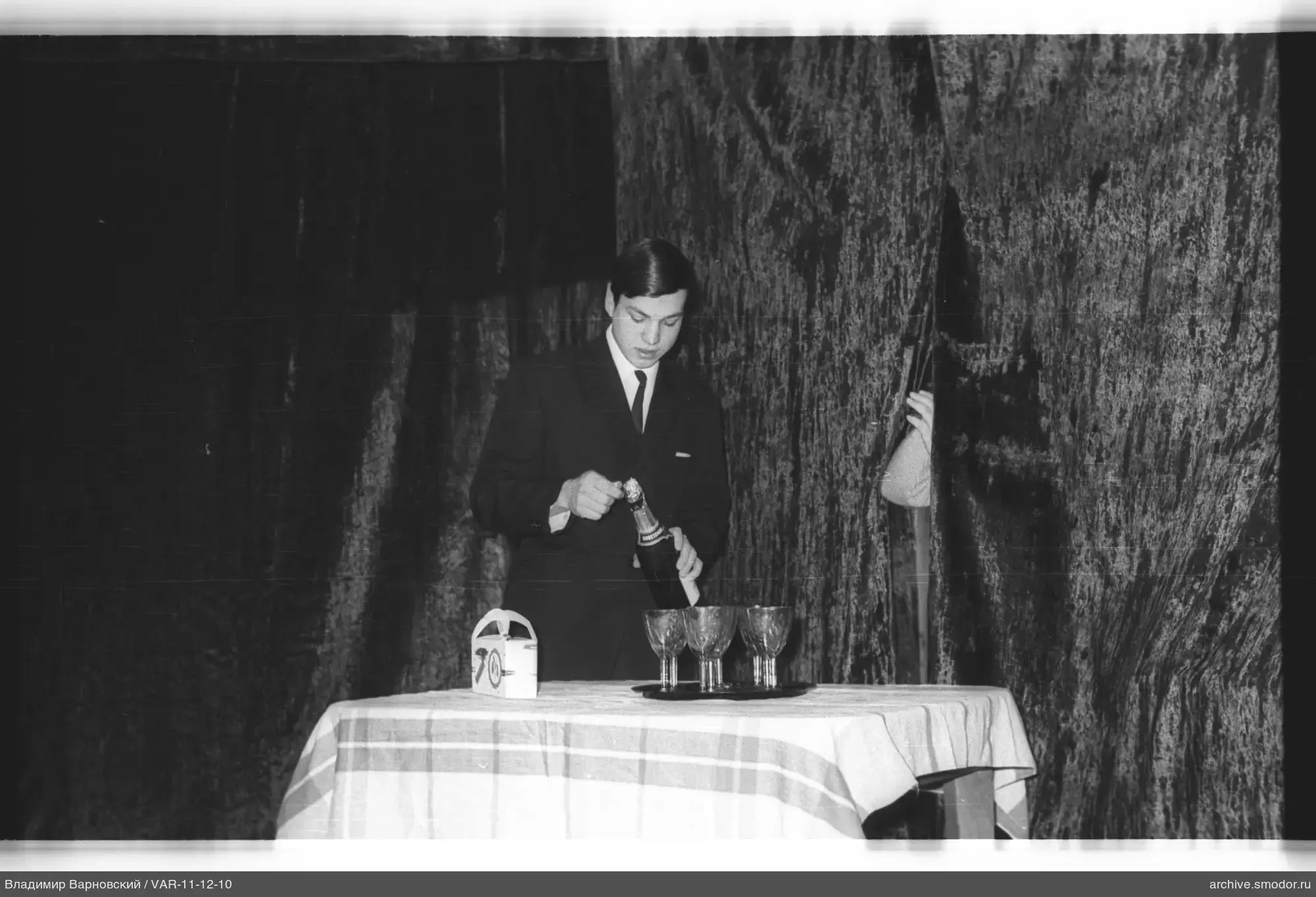 Mann öffnet Champagner am Tisch