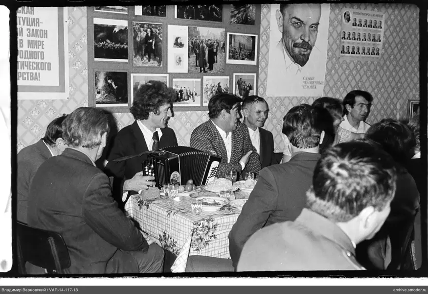 Gruppe am Tisch mit Postern und Musiker
