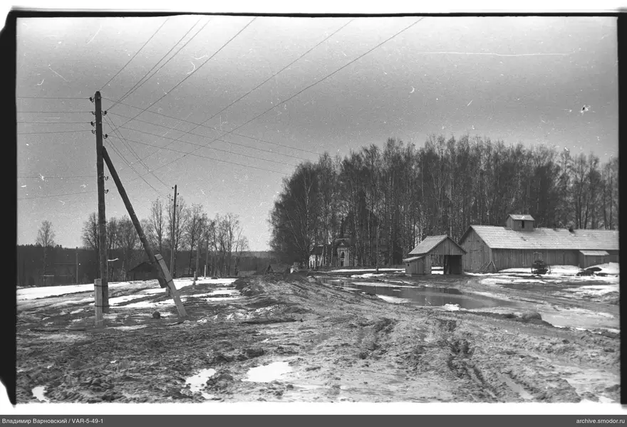 Грязная дорога с деревьями и постройками