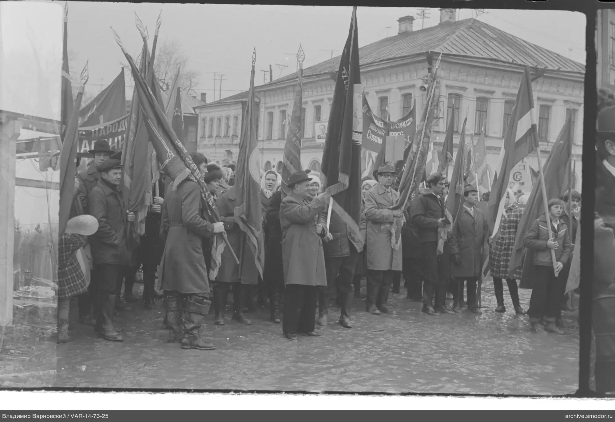 Gruppe von Menschen mit Fahnen vor einem Gebäude