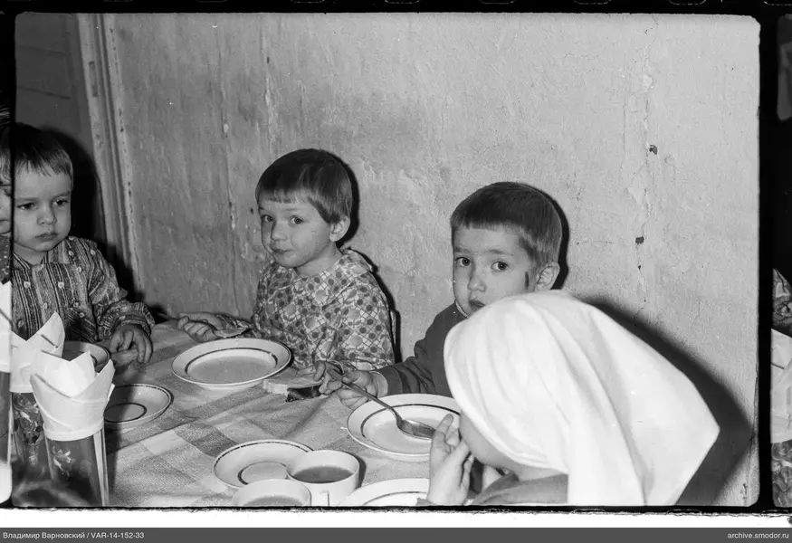 Kinder am Tisch mit Geschirr