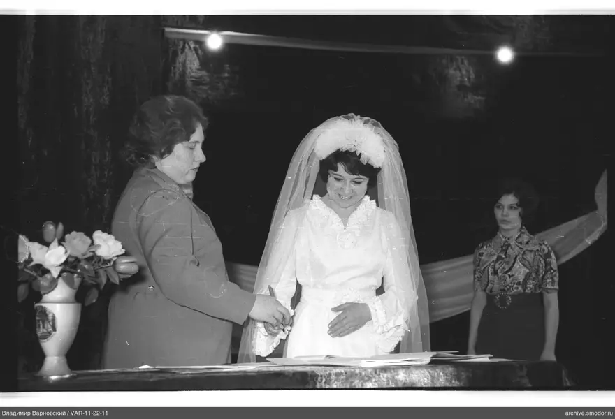 Woman in white dress with veil at table