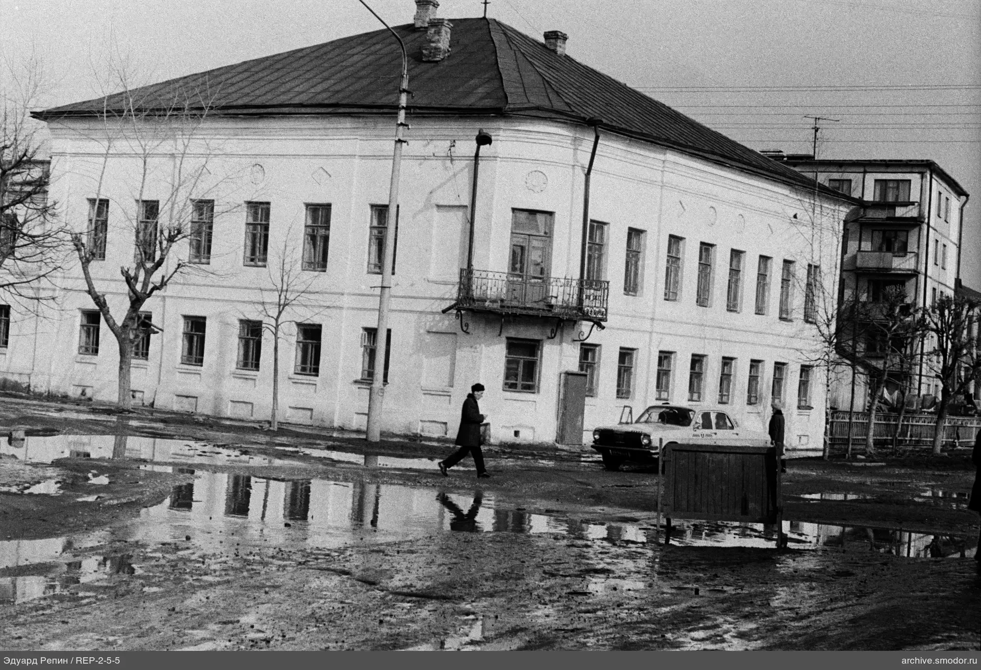 Двухэтажное здание с балконом и людьми