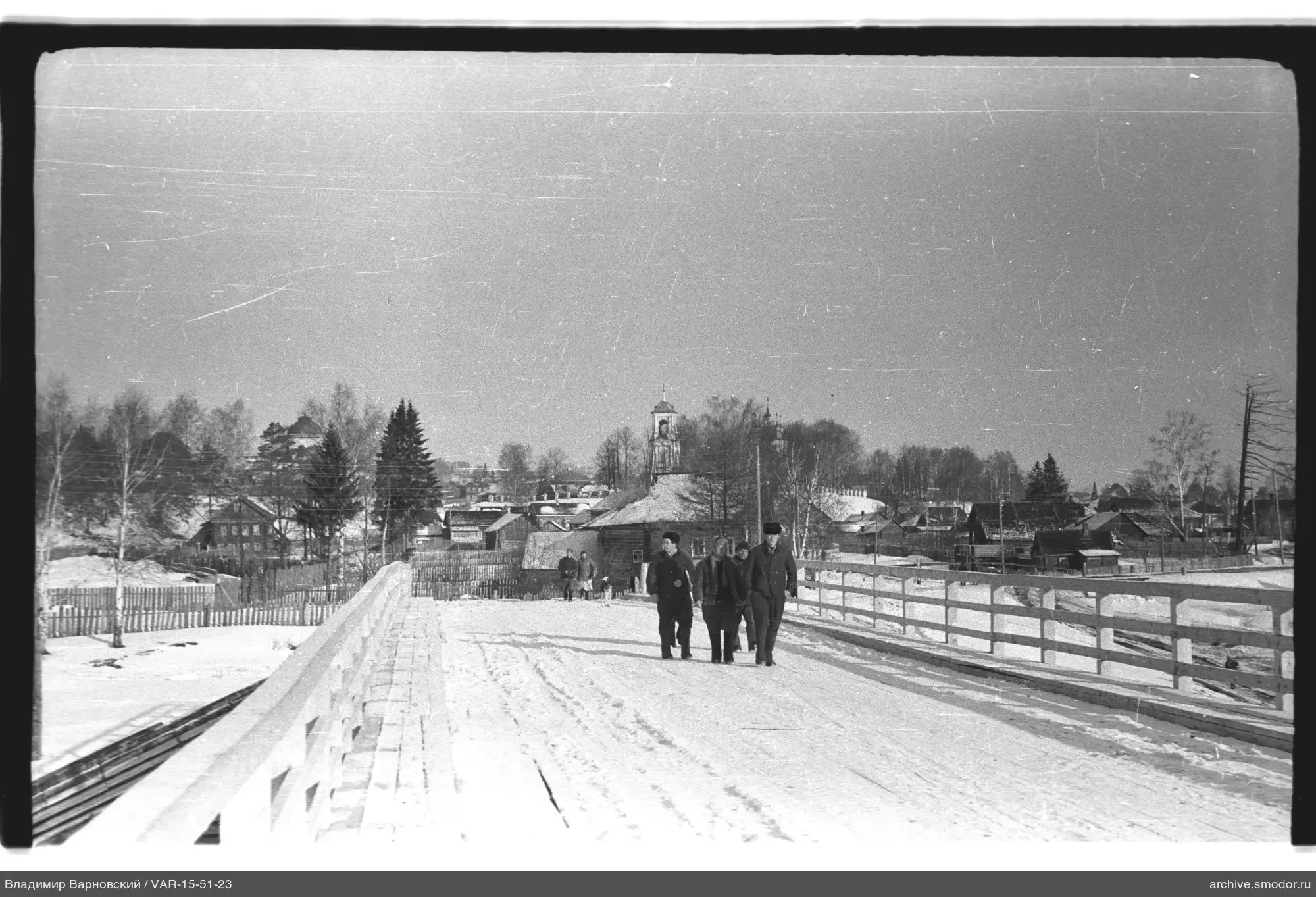 Fünf Männer auf einer verschneiten Holzbrücke