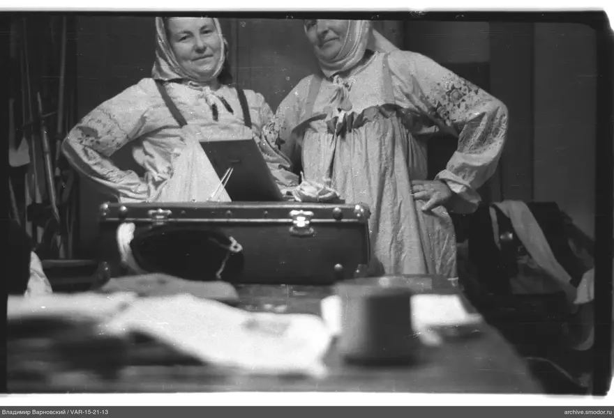 Two women with hands on waists at table