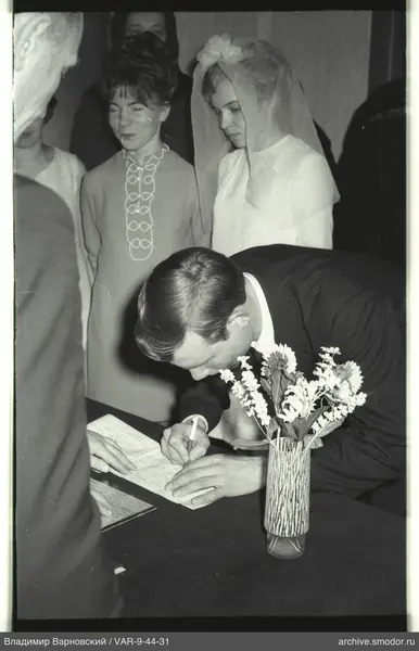 Man writing at a table with women