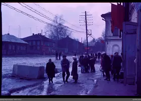 Группа людей на грязной улице с флагами