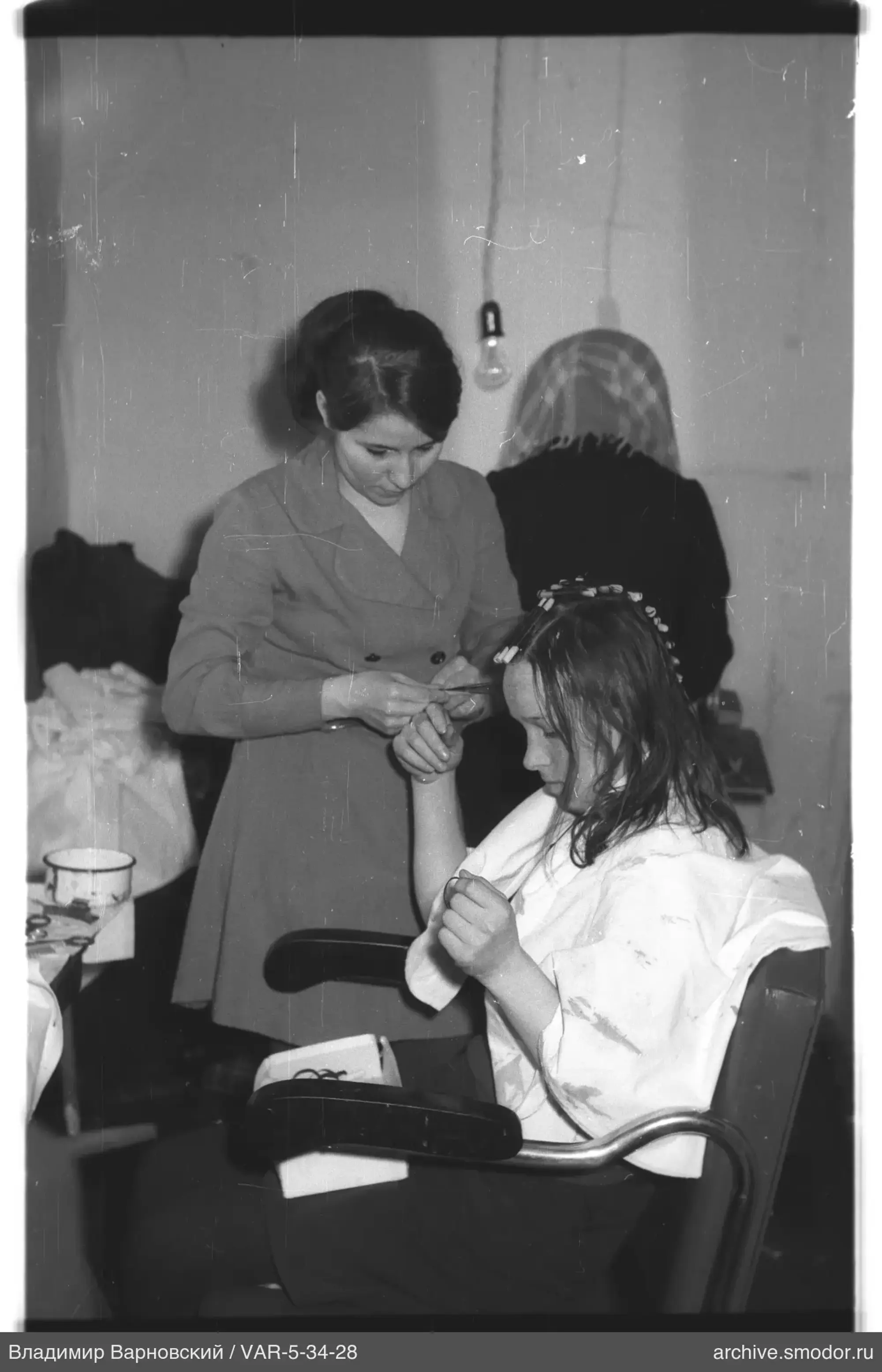 Woman working with girl with curlers