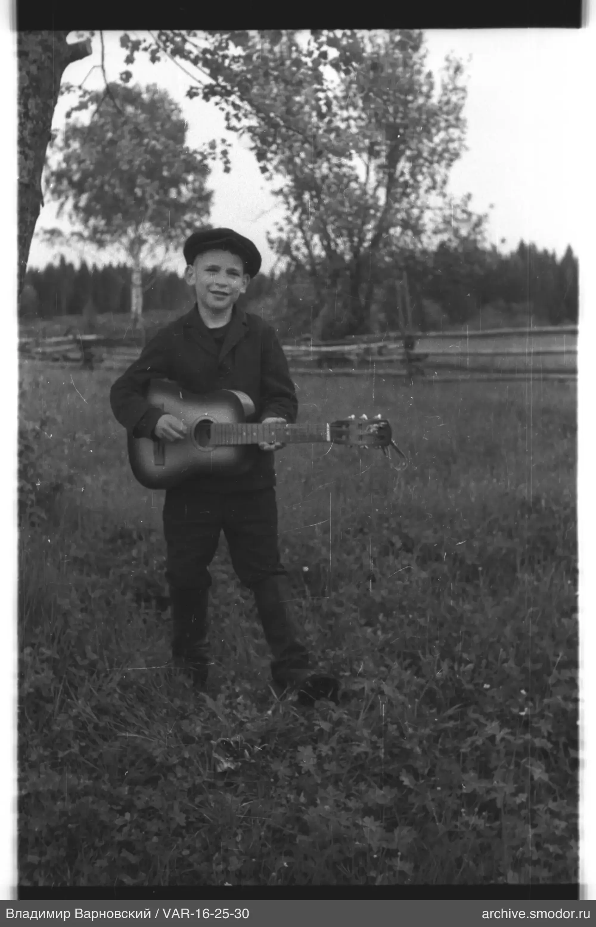 Junge mit Gitarre auf Feld