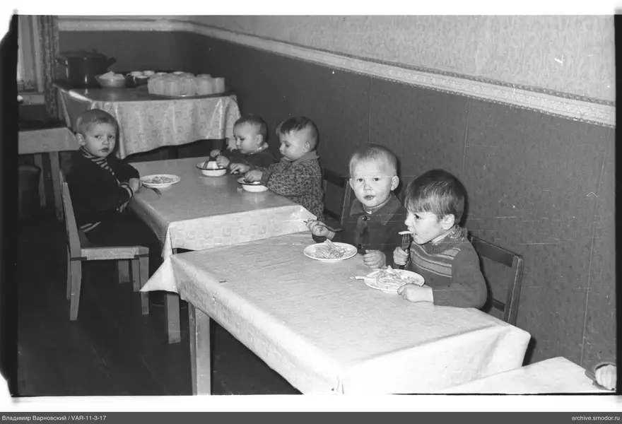 Children sitting at tables during event