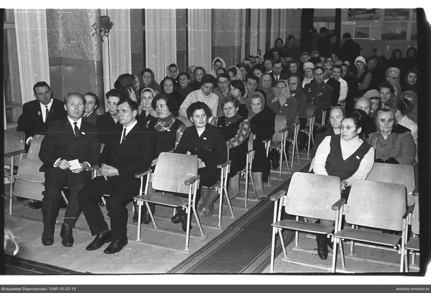 Men and women seated at an event in a hall
