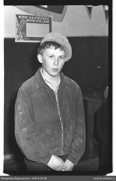 Teenager with knitted hat in front of inscription