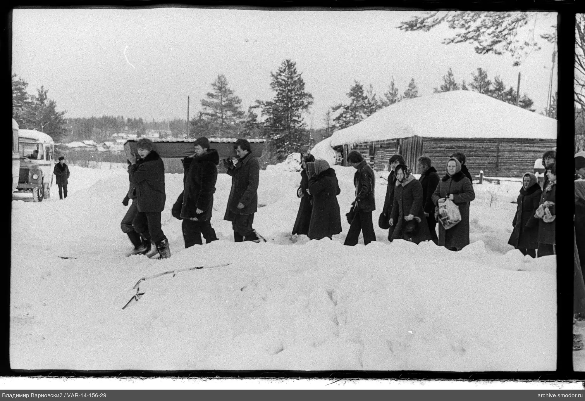 Gruppe mit Sarg auf verschneiter Straße