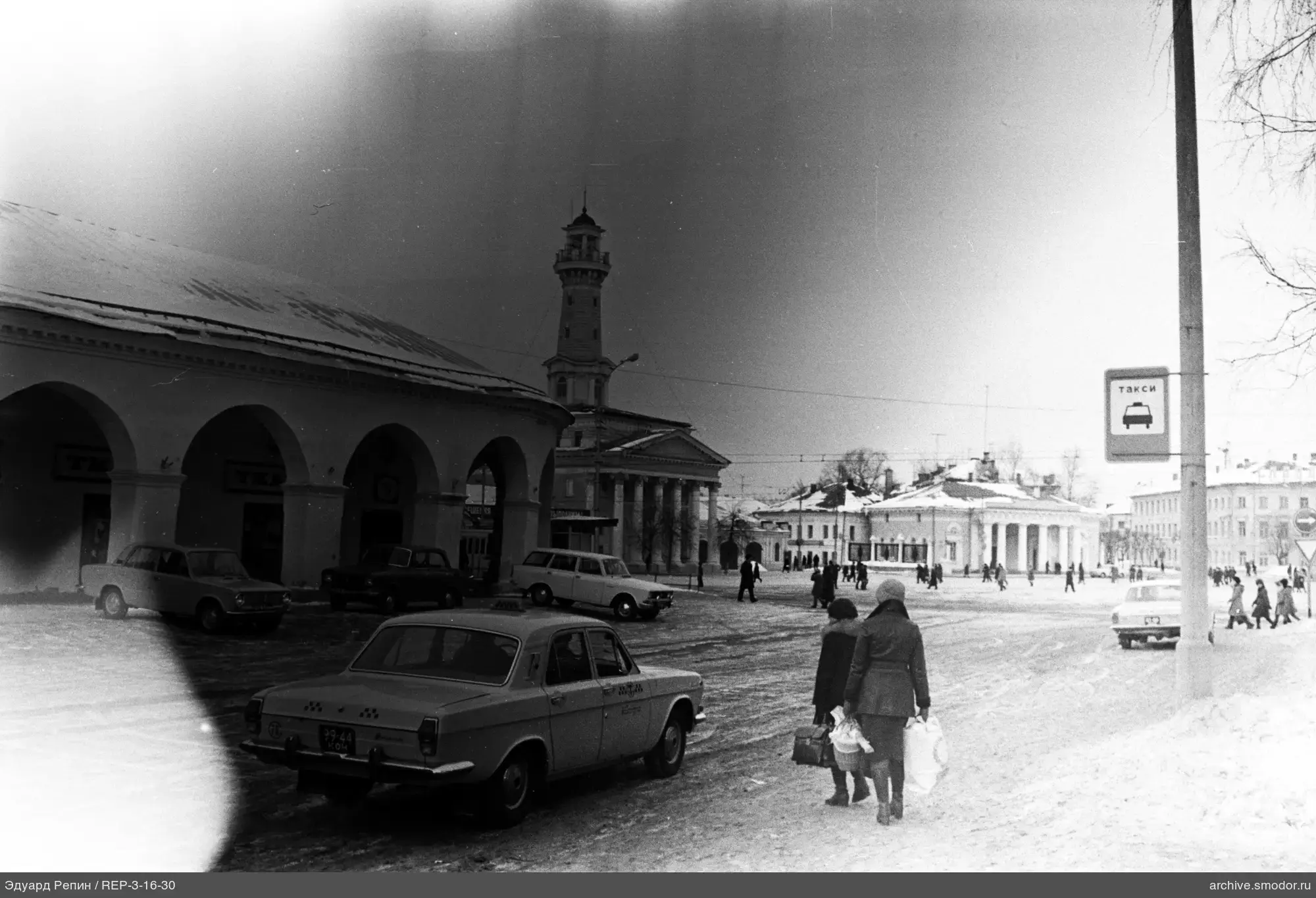 Городская площадь с заснеженной дорогой и зданиями