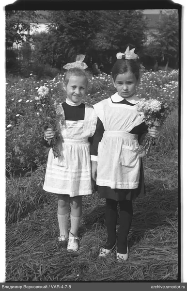 Zwei Mädchen mit Blumensträußen auf dem Gras