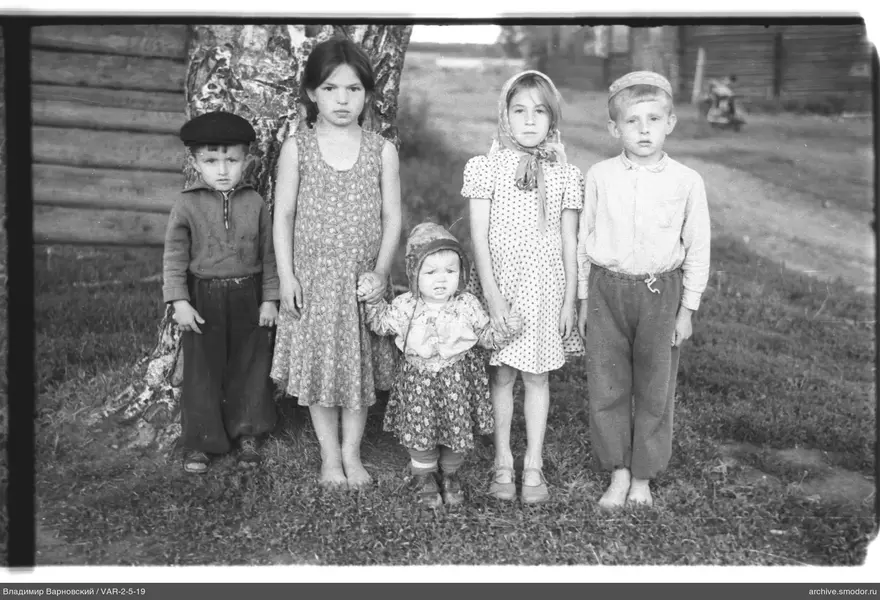 Gruppe von Kindern am Birkenbaum und Haus