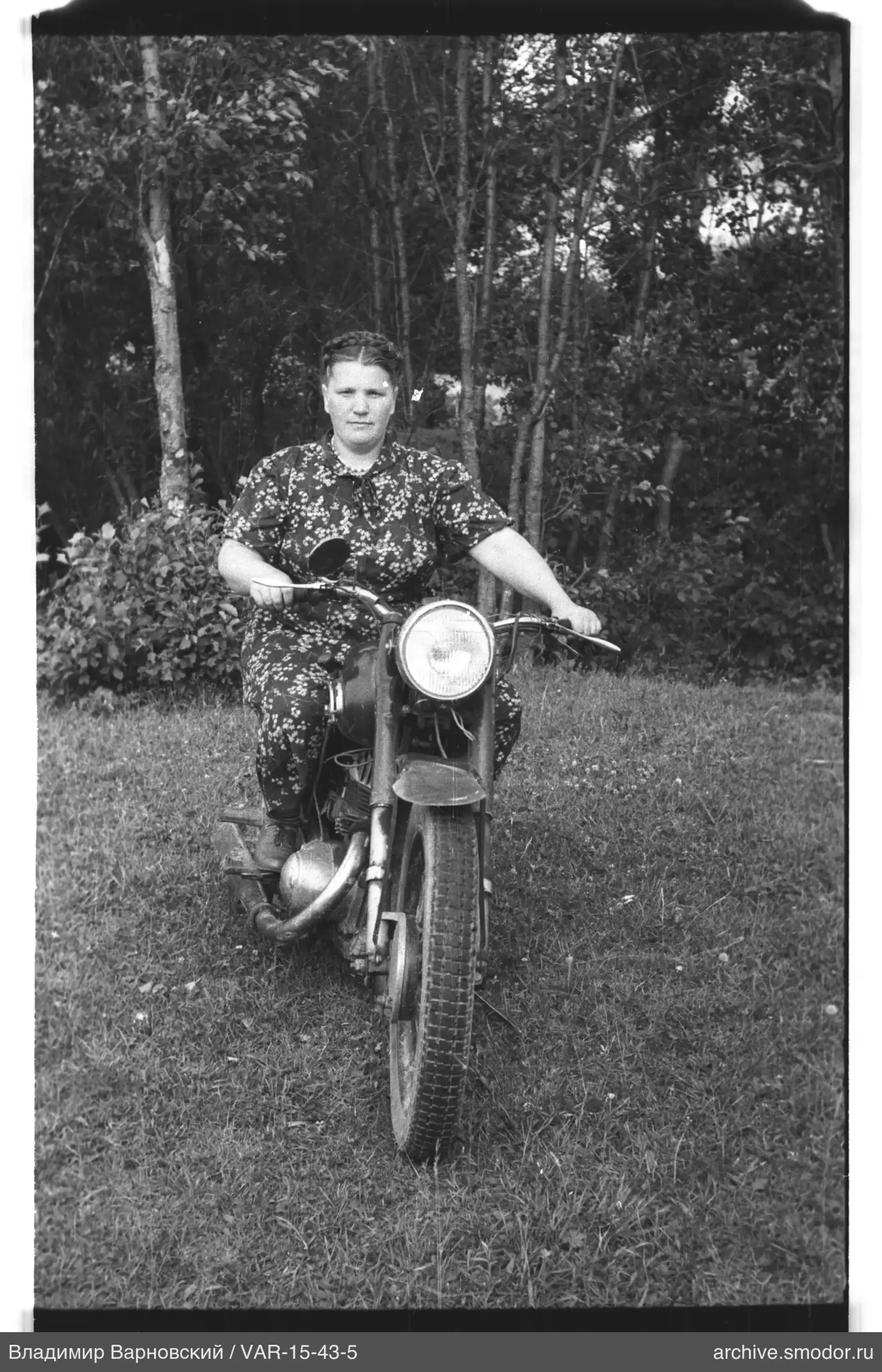 Frau auf Motorrad vor Bäumen