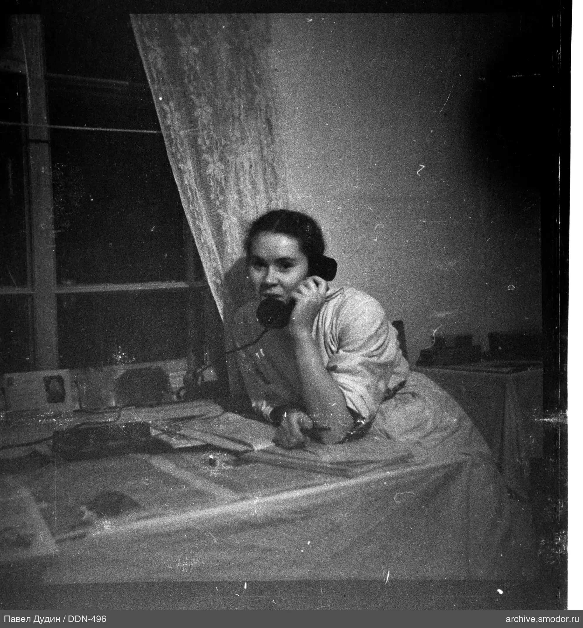 Frau mit Telefon am Fenster
