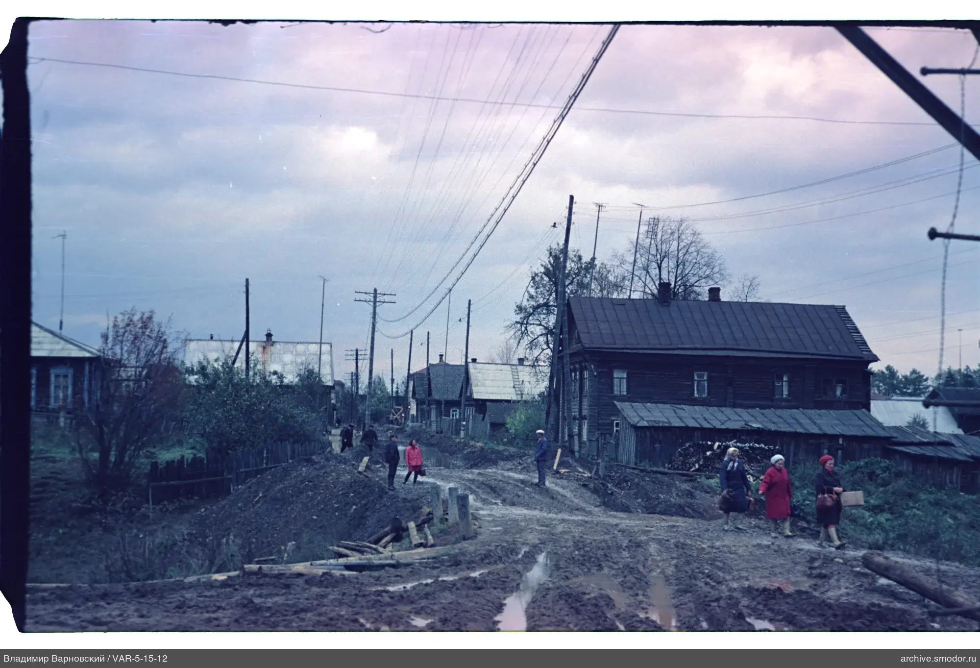 Straße mit Holzhaus und Menschen