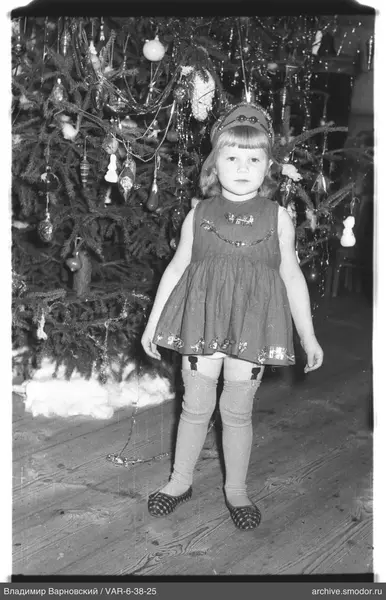Mädchen vor geschmücktem Weihnachtsbaum