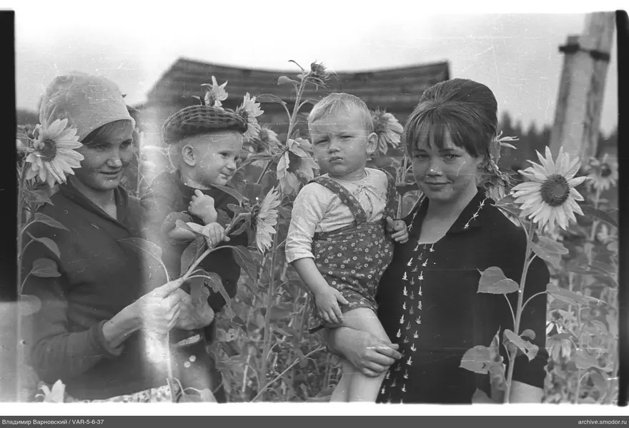 Gruppe von Frauen und Kindern zwischen Sonnenblumen