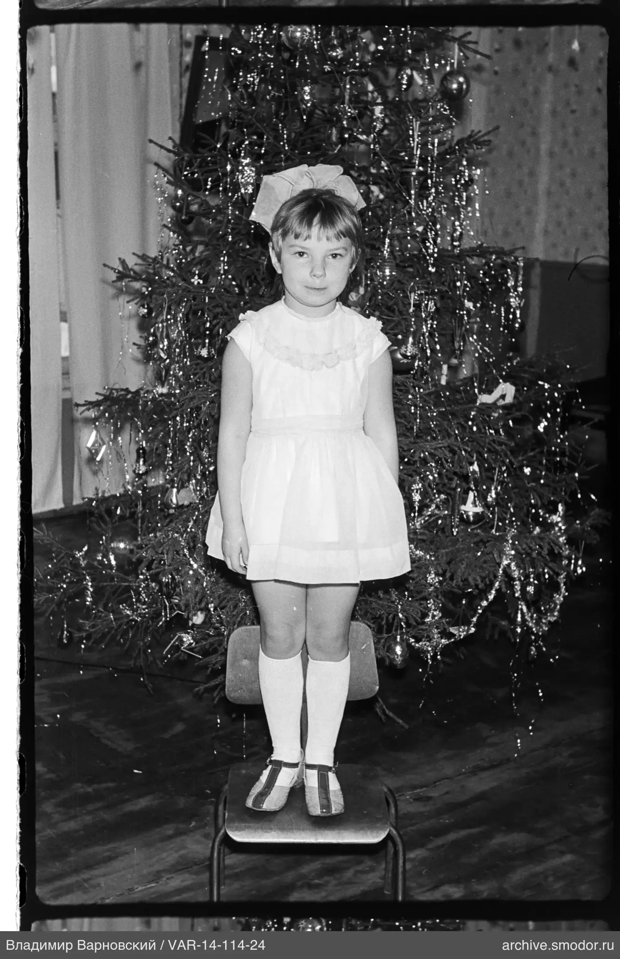 Mädchen vor geschmücktem Weihnachtsbaum