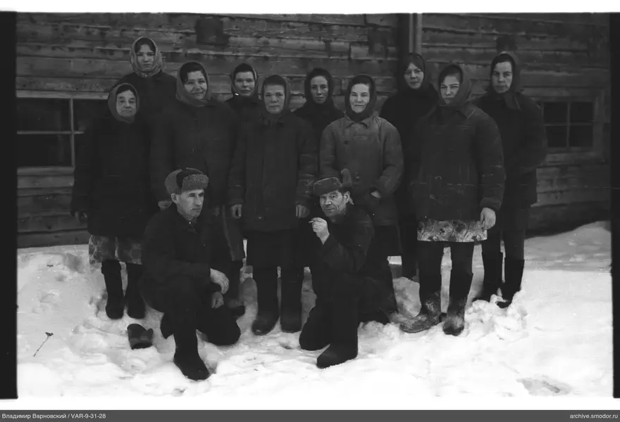 Gruppenporträt im Schnee bei Holzgebäude
