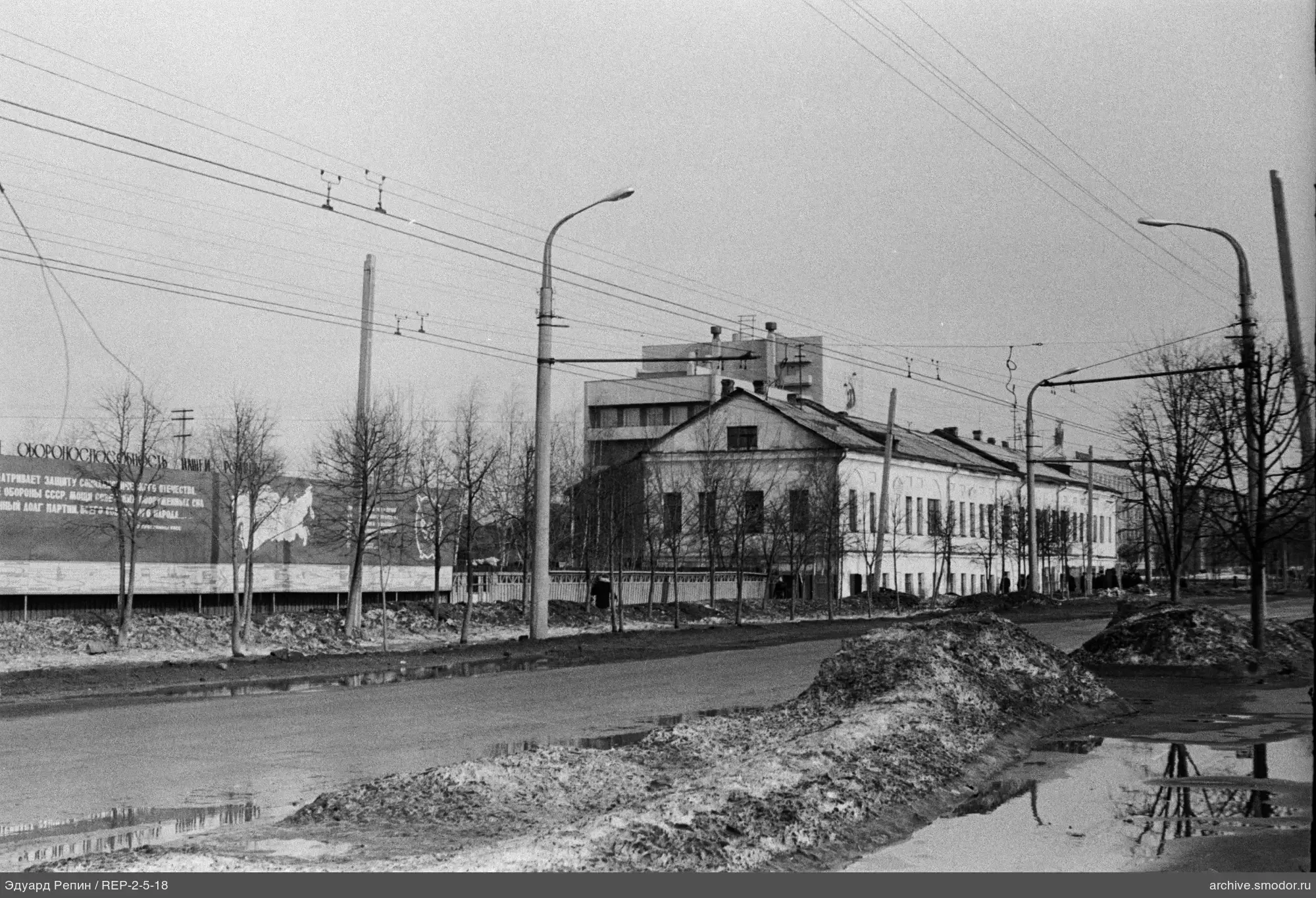 Straße mit Schneehaufen und zweistöckiges Gebäude