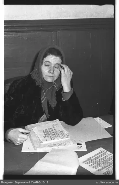 Woman with papers at wooden wall