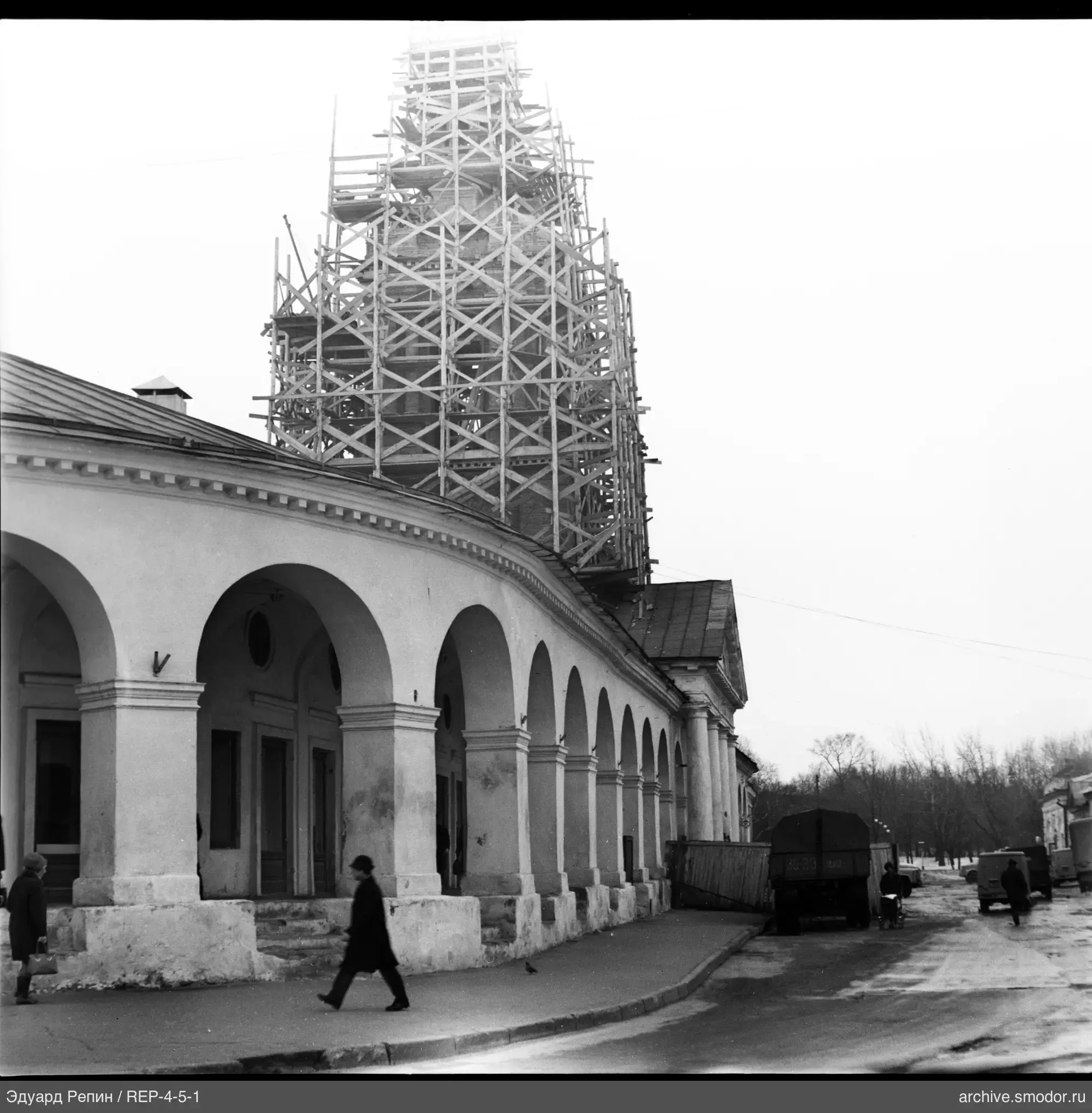 Каменное здание с башней и прохожими