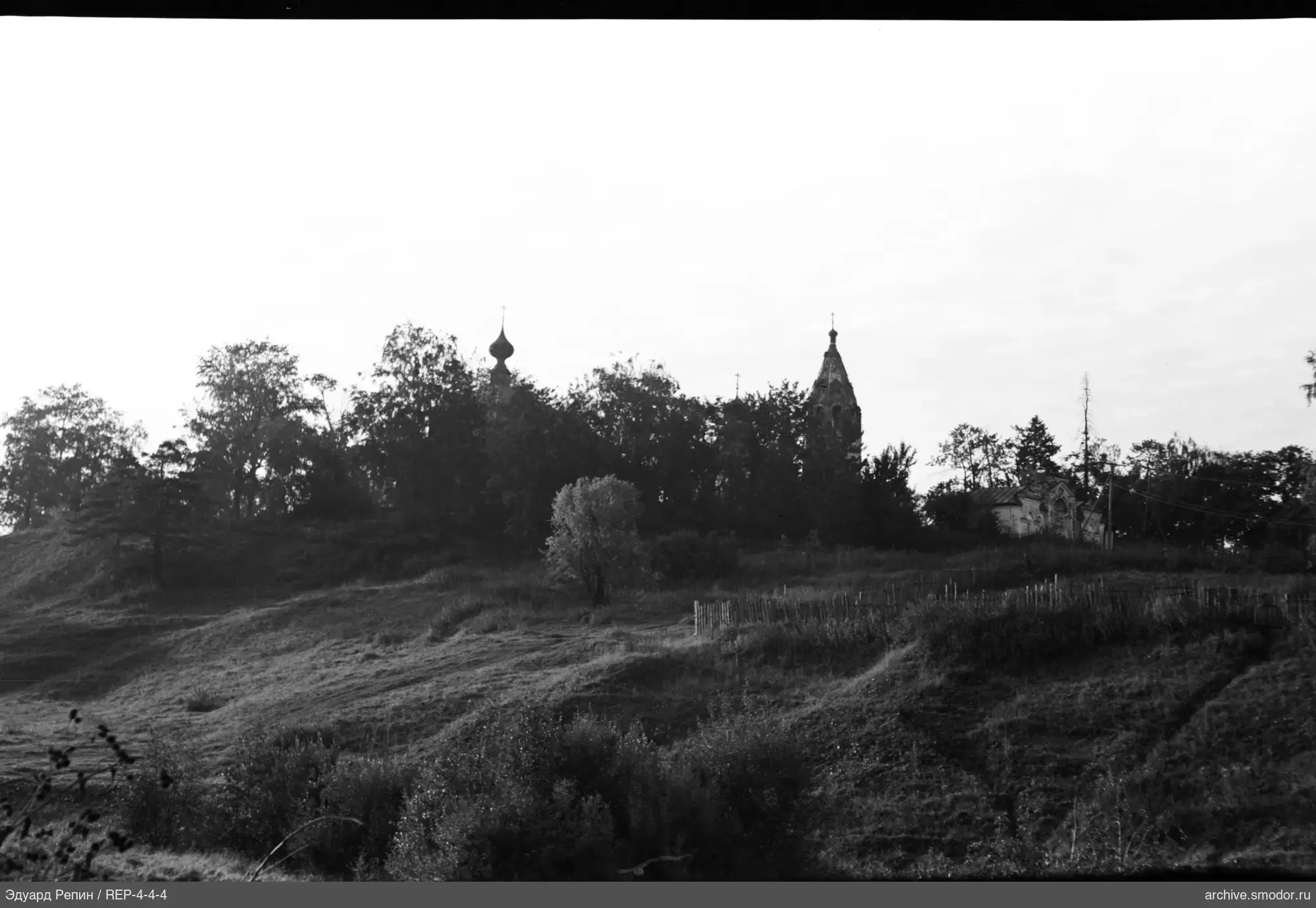Hügelige Landschaft mit Kirchen und Bäumen