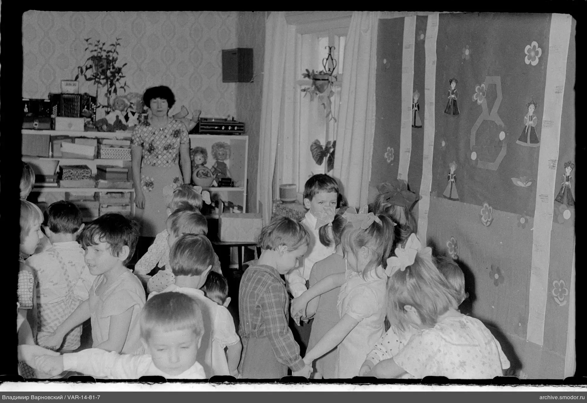 Kinder im Kreis mit Frau im Raum
