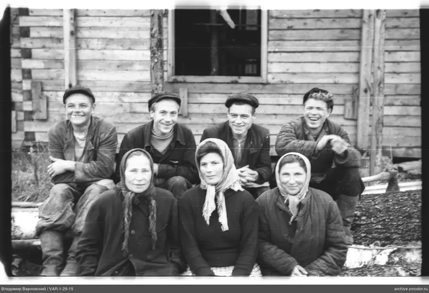 Gruppe von Menschen bei Holzgebäude