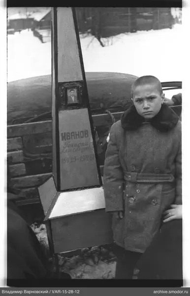 Junge neben Denkmal mit Foto